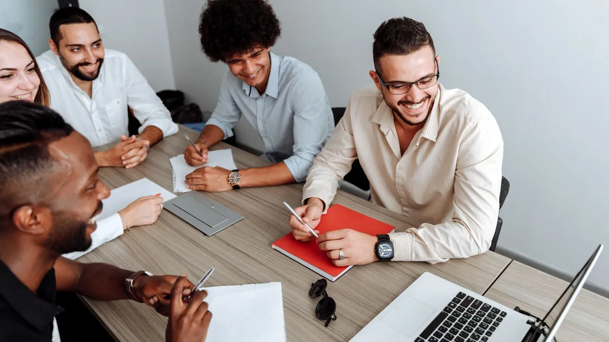 A group of diverse professionals collaborating during a team meeting in a modern office setting.