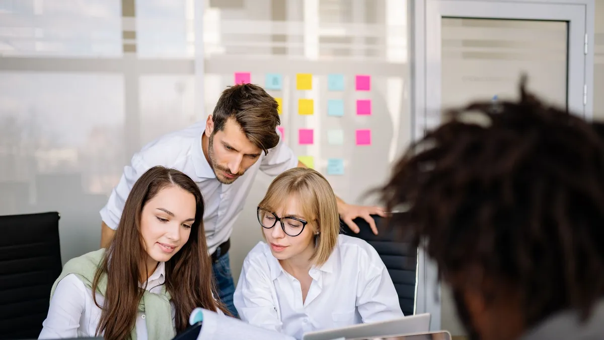 A diverse team of professionals collaborating on paperwork in a modern office setting.