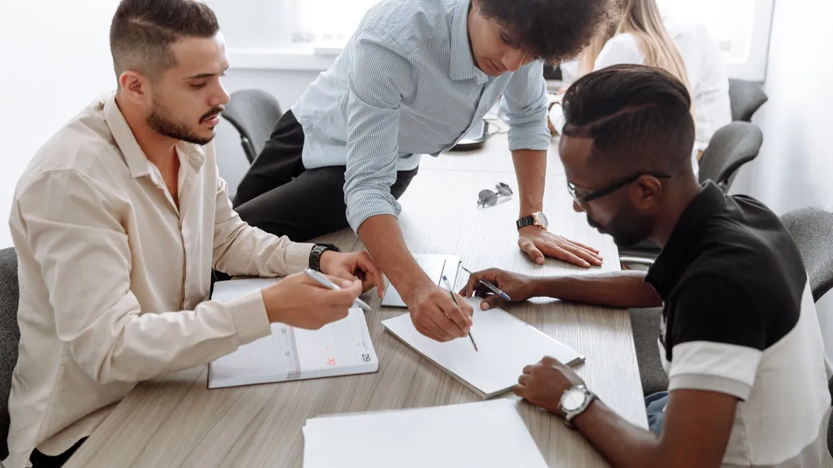 A diverse team of professionals collaborating in a modern office setting, focusing on brainstorming and planning.