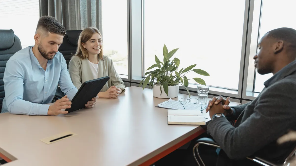 A business interview with three people in a modern office room, highlighting collaboration.