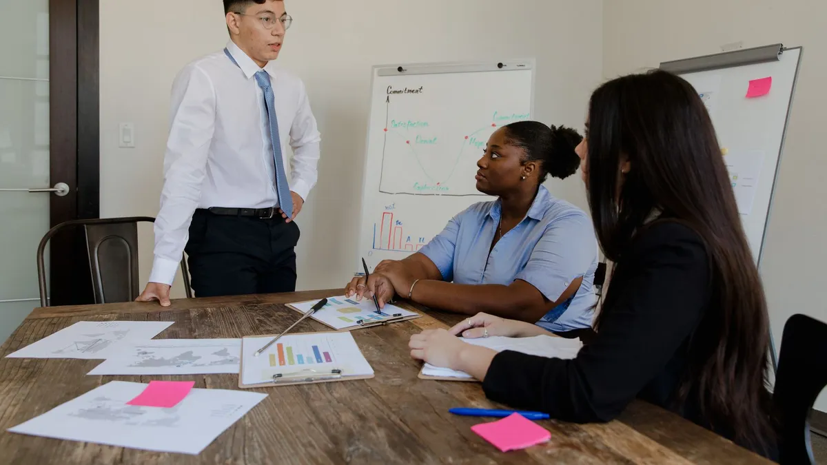 A diverse group of professionals engaged in a meeting around a boardroom table.