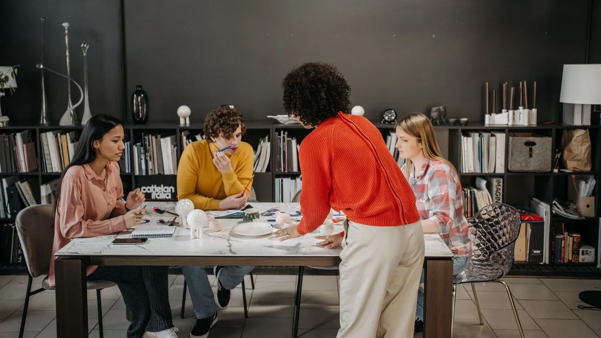 A diverse team engaged in a brainstorming session at a modern office table with documents and ceramics.