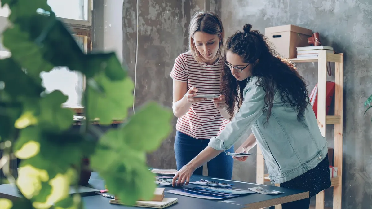Two designers working together at a table in a stylish urban studio.