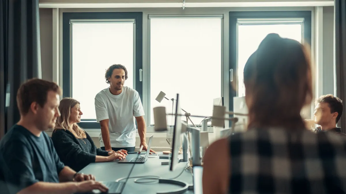 A diverse team engaged in discussion during a collaborative office meeting.