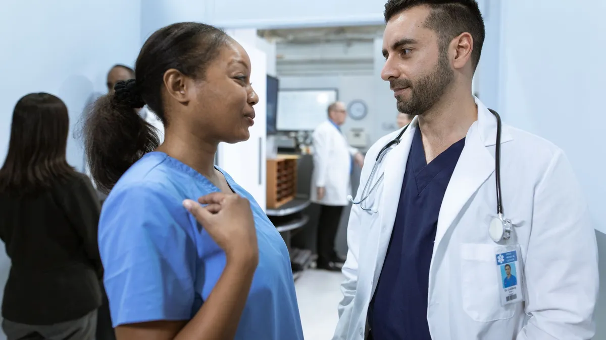 Medical professionals discussing patient care in a hospital hallway.