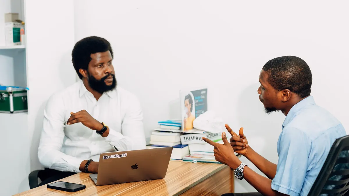 Two adults engaged in a professional consultation in a Lagos office, discussing business or healthcare topics.