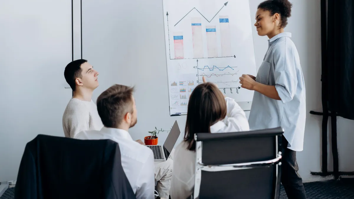 Multicultural team in office brainstorming business strategy with charts.