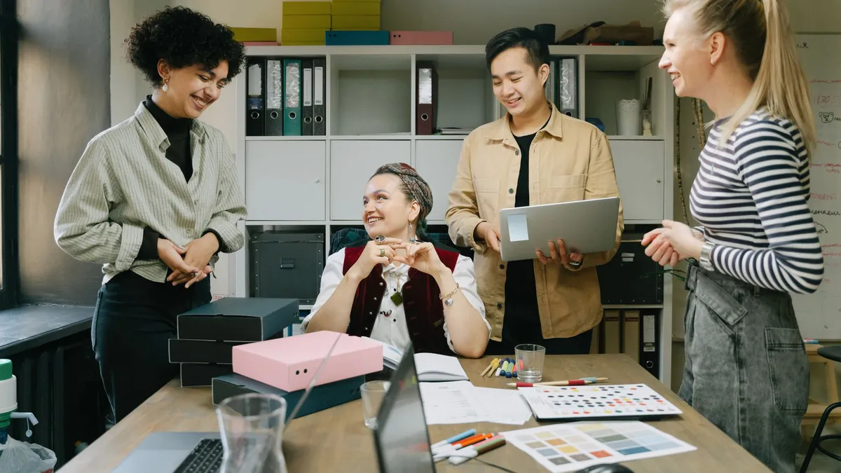 Colleagues engage in a lively discussion during a team meeting in a modern office setting.