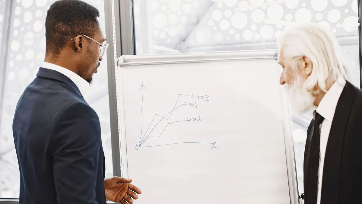 Two businessmen discussing financial charts at an office meeting.