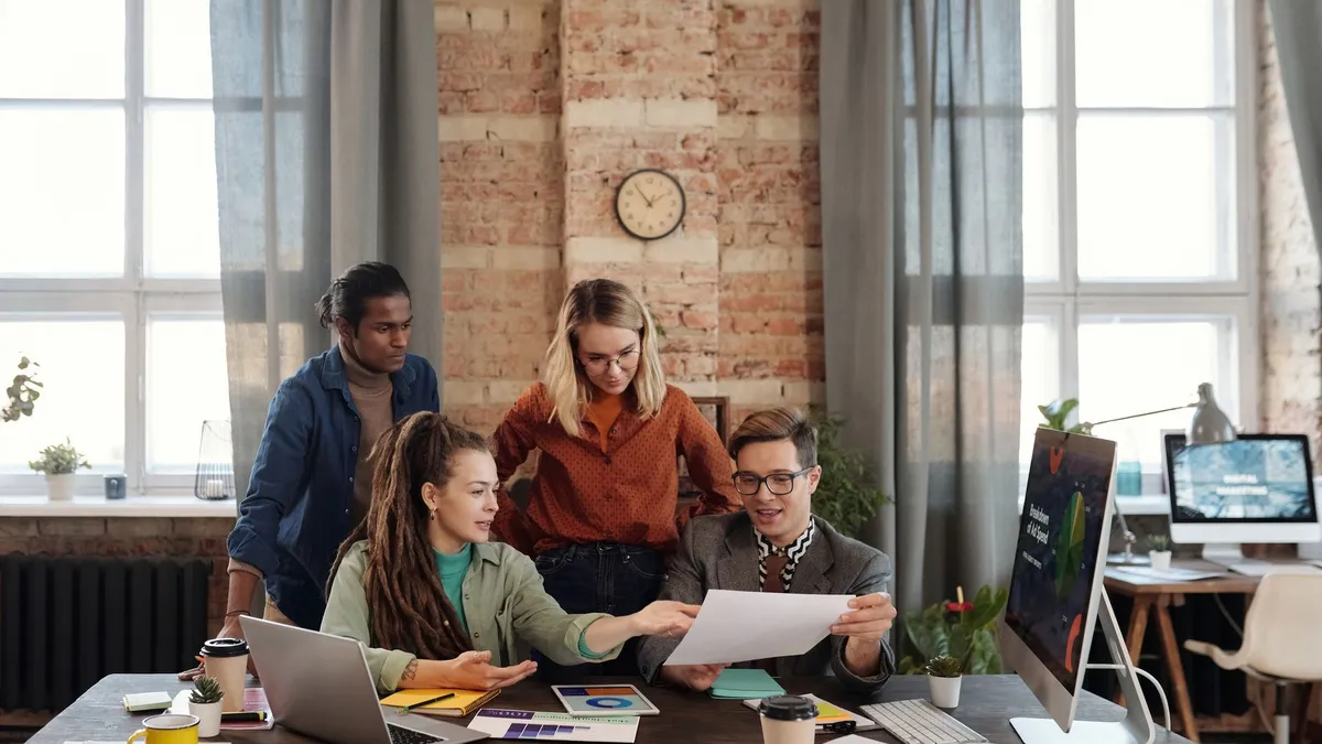 A diverse team of young professionals working on a business strategy in an urban office setting.