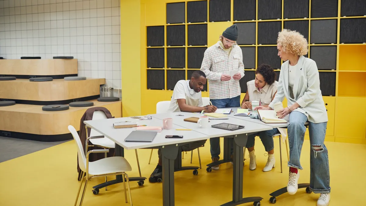 A diverse group of coworkers actively brainstorming and collaborating in a modern, colorful office setting.