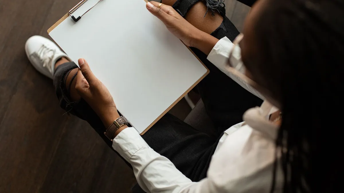 Top view of a person with a blank clipboard, ideal for mockup designs.
