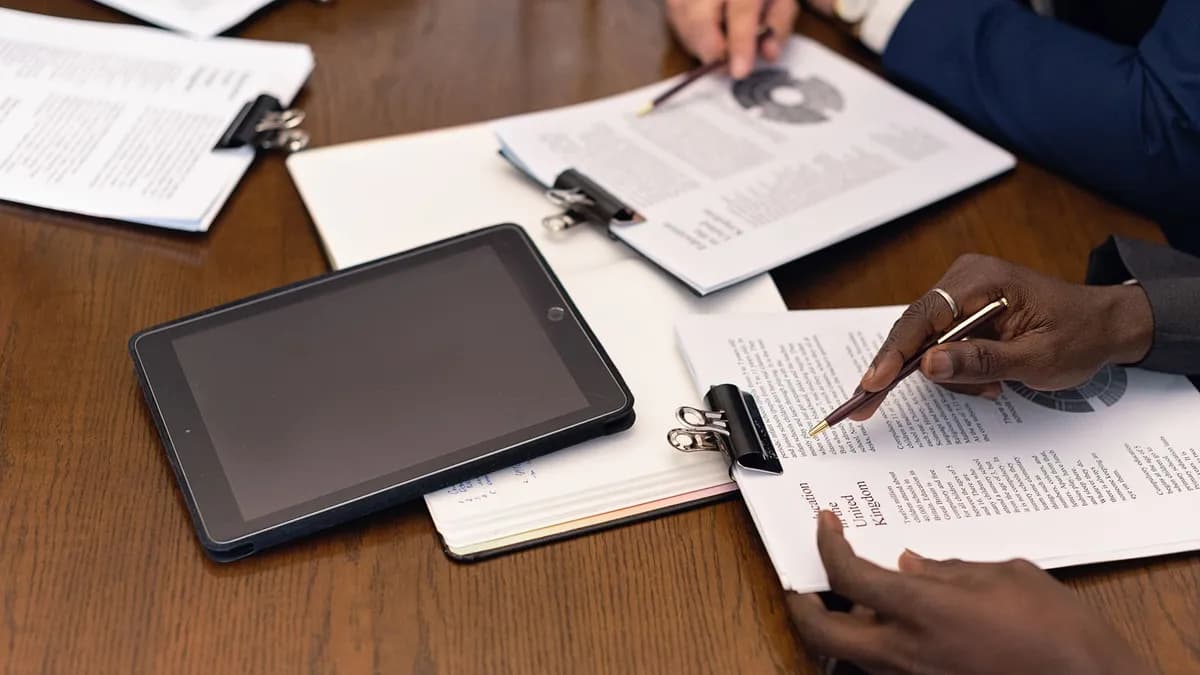 A business meeting with tablets and documents, showcasing digital integration in a professional setting.