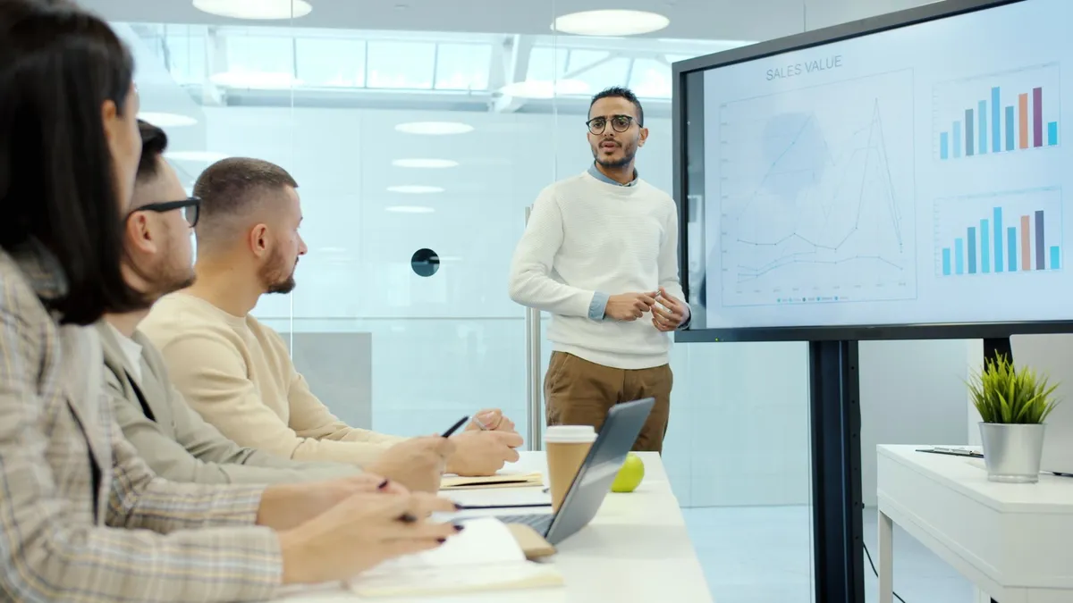 Business team in a modern office, discussing charts during a presentation.