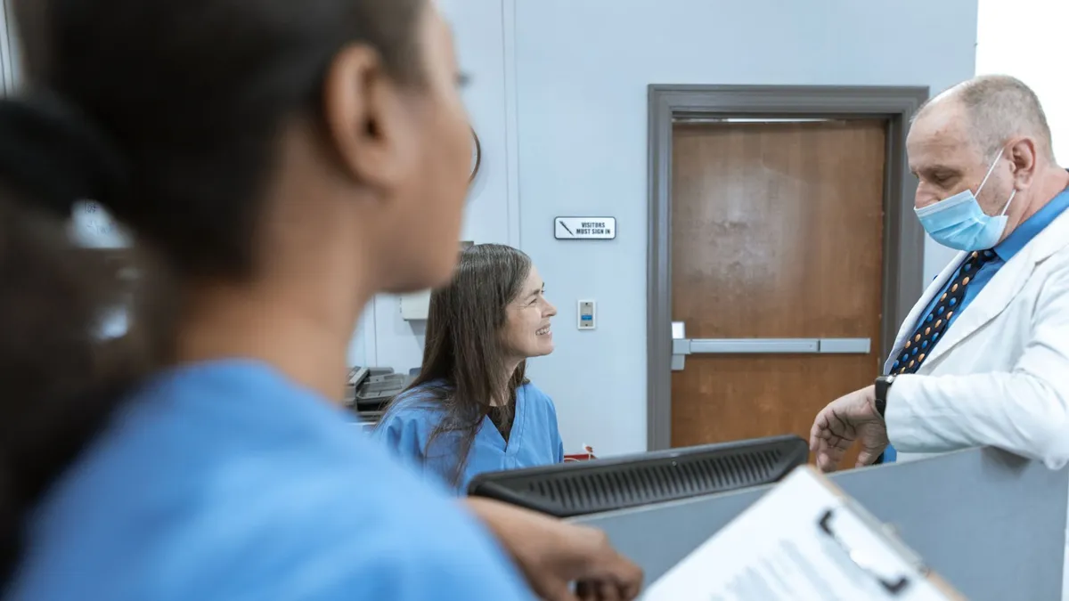 Healthcare professionals in discussion at a hospital reception, emphasizing teamwork and communication.