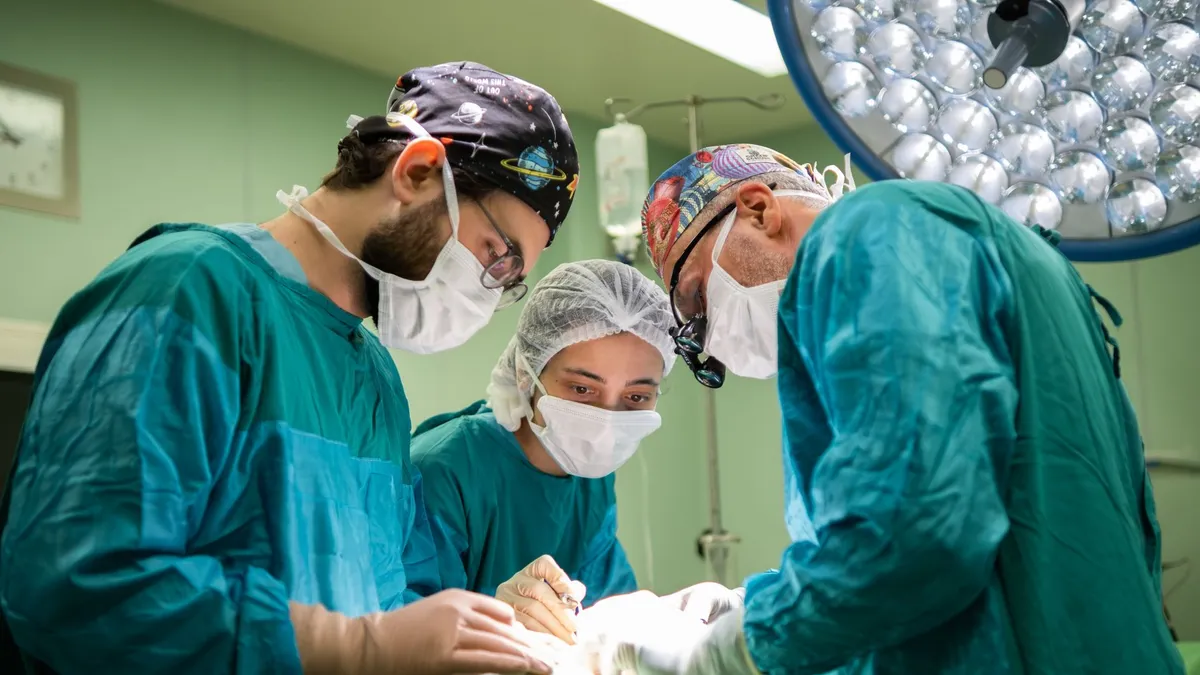 A focused surgical team operating in a brightly lit hospital room, showcasing teamwork and precision.