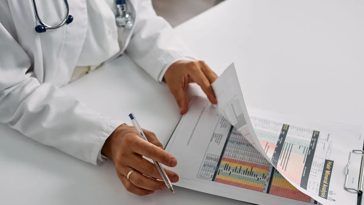 A medical professional checking patient reports with a clipboard in an office setting.
