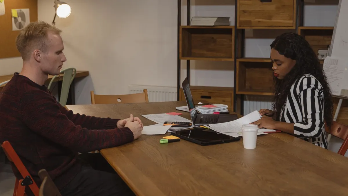 Two professionals engaged in a business meeting at a modern office, discussing strategies.
