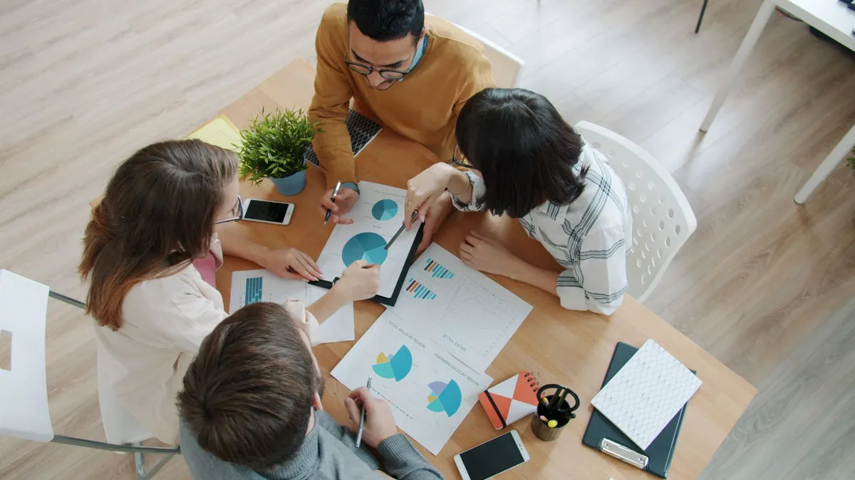 Group of professionals reviewing business charts around a table.