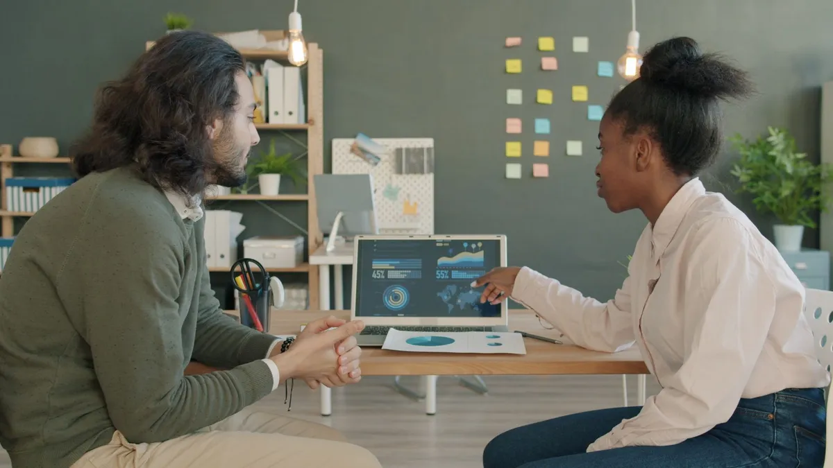 Two professionals collaborating on data analysis in a modern office.