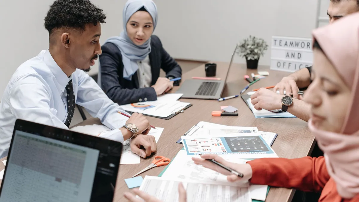 A diverse group of professionals collaborating in an office setting, focusing on teamwork and discussion.