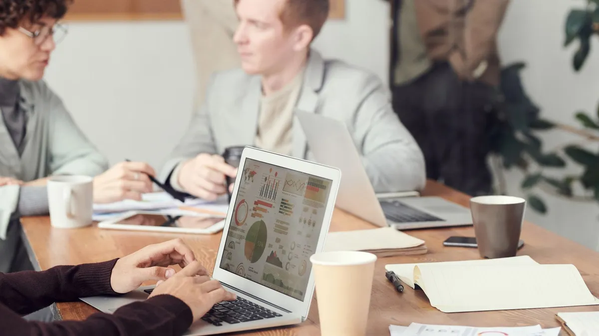 Professionals collaborating in an office setting, focused on digital data analysis during a meeting.