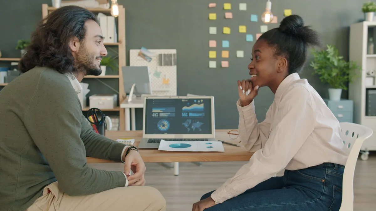 Two colleagues discussing data analytics in a creative office space.