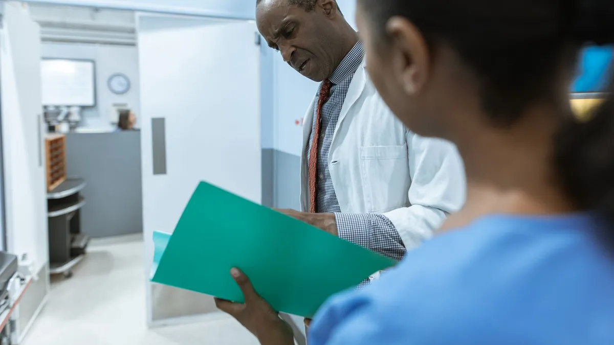 Doctors examining a folder in a hospital setting, highlighting teamwork and healthcare professionalism.