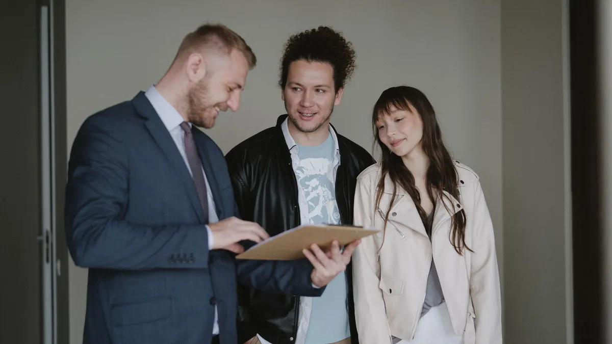 Happy couple meeting with a real estate agent discussing paperwork indoors.