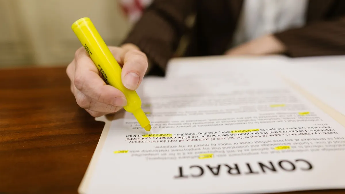 A close-up of a hand highlighting a contract, emphasizing important legal terms.