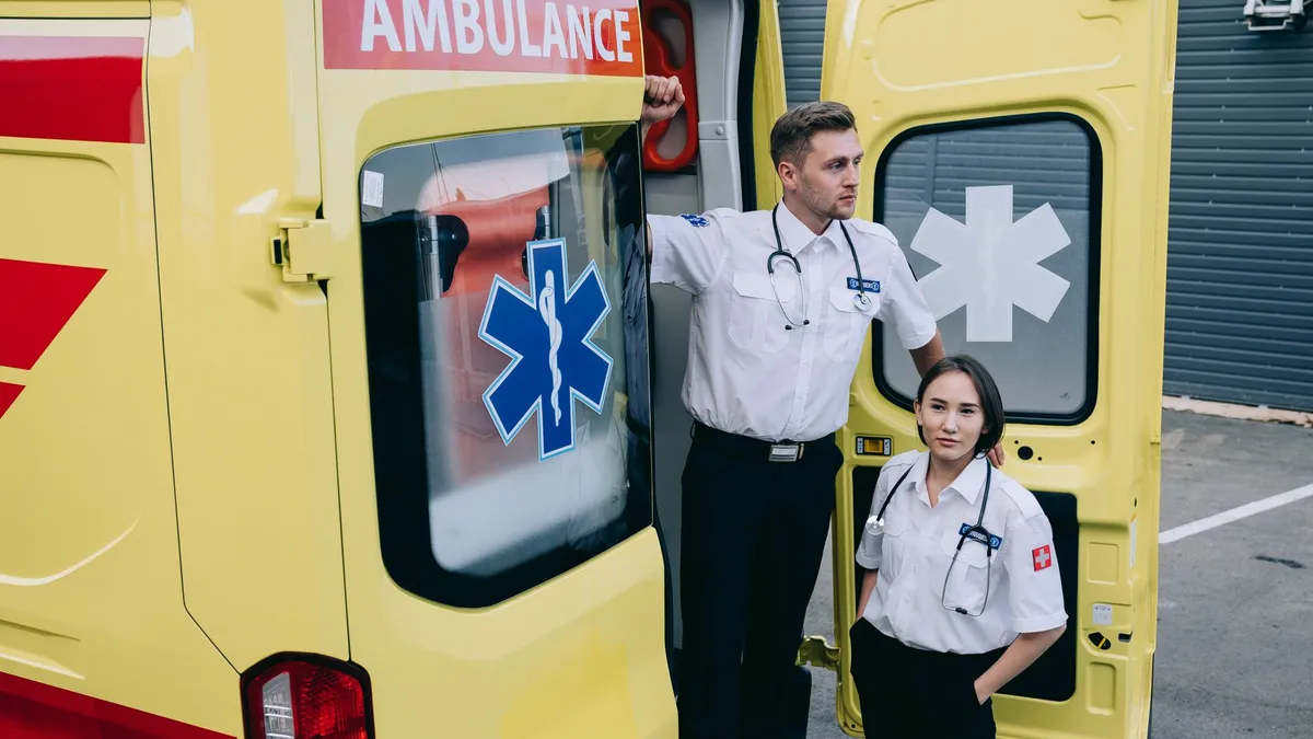 Paramedics stand by a yellow ambulance, ready to assist in emergencies.