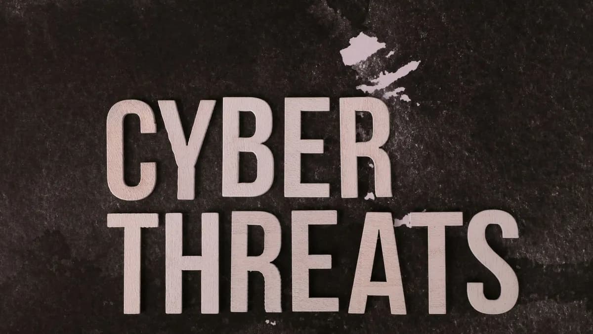 The phrase 'Cyber Threats' displayed on a textured dark background, emphasizing digital security.