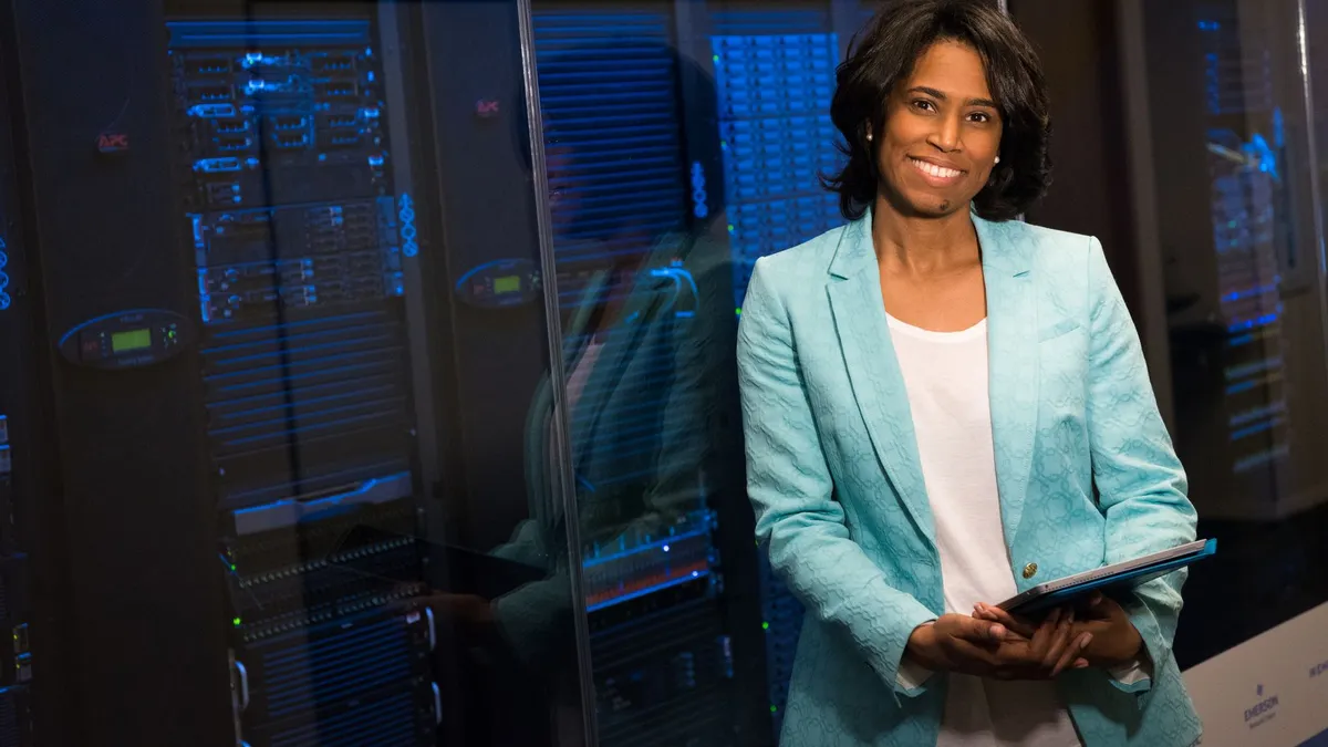 Smiling woman in data center showcasing technology expertise.
