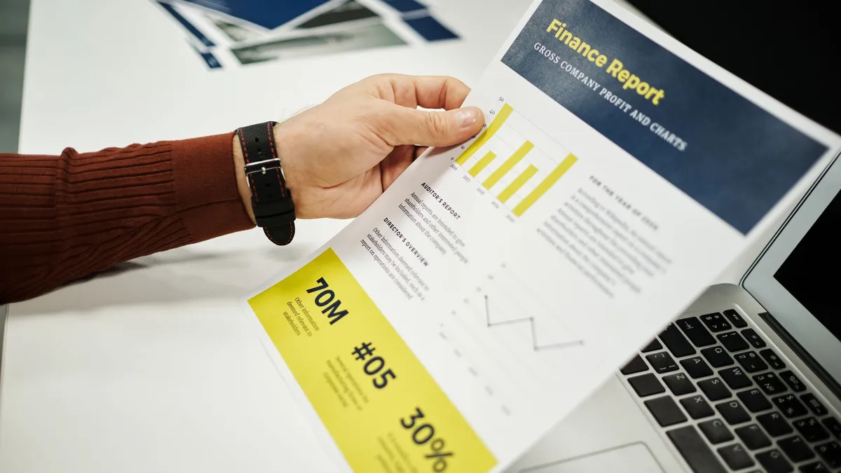 Person analyzing finance report with graphs at desk, ideal for business concepts.