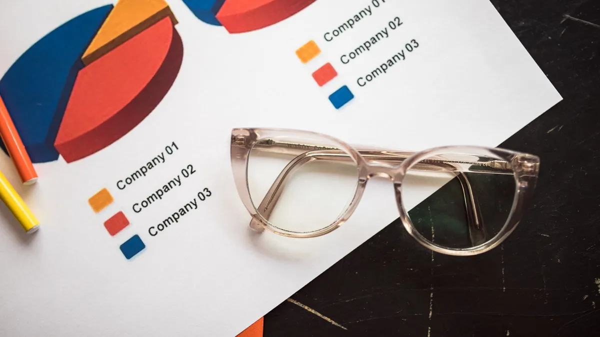 Photo of business charts and eyeglasses on a desk, ideal for finance and analytics themes.