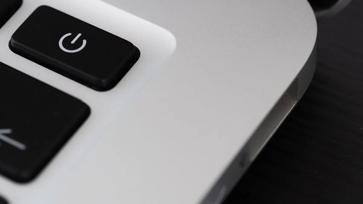 Detailed view of a power button on a sleek laptop, emphasizing technology design.