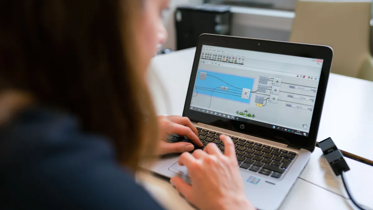 A woman engineer focuses on software analysis using a laptop indoors.