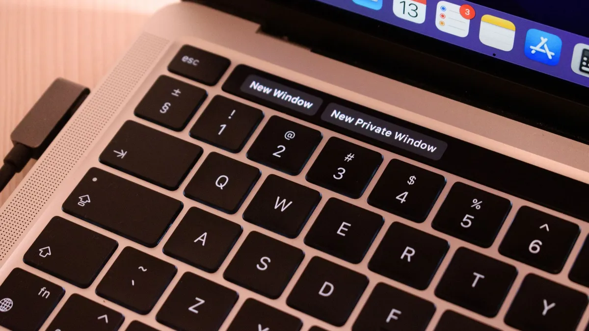 A detailed view of a laptop keyboard with browser tabs open, highlighting 'New Window' and 'New Private Window'.