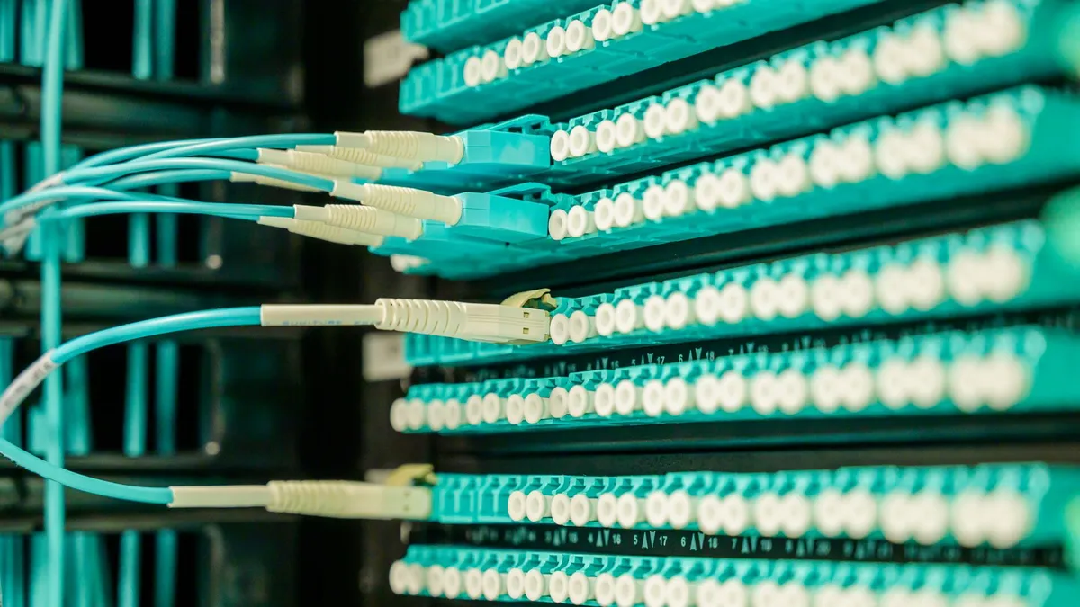 Networking cables plugged into a patch panel, showcasing data center connectivity.
