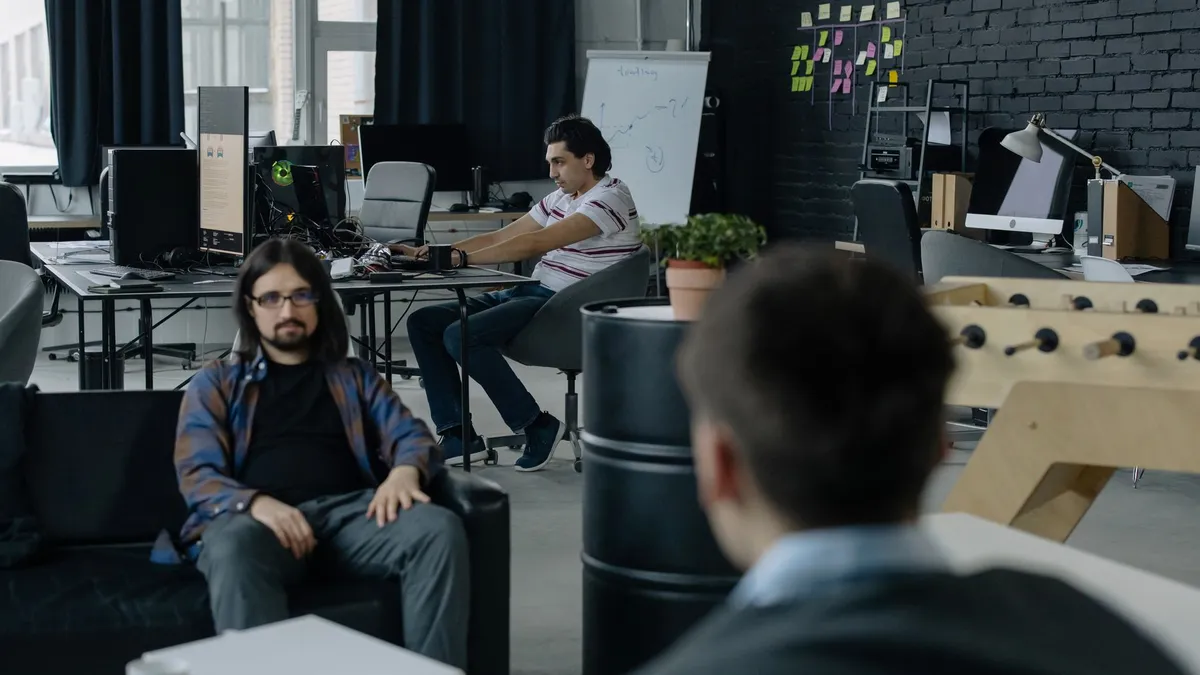 Team of professionals collaborating in a modern open office space with multiple workstations.