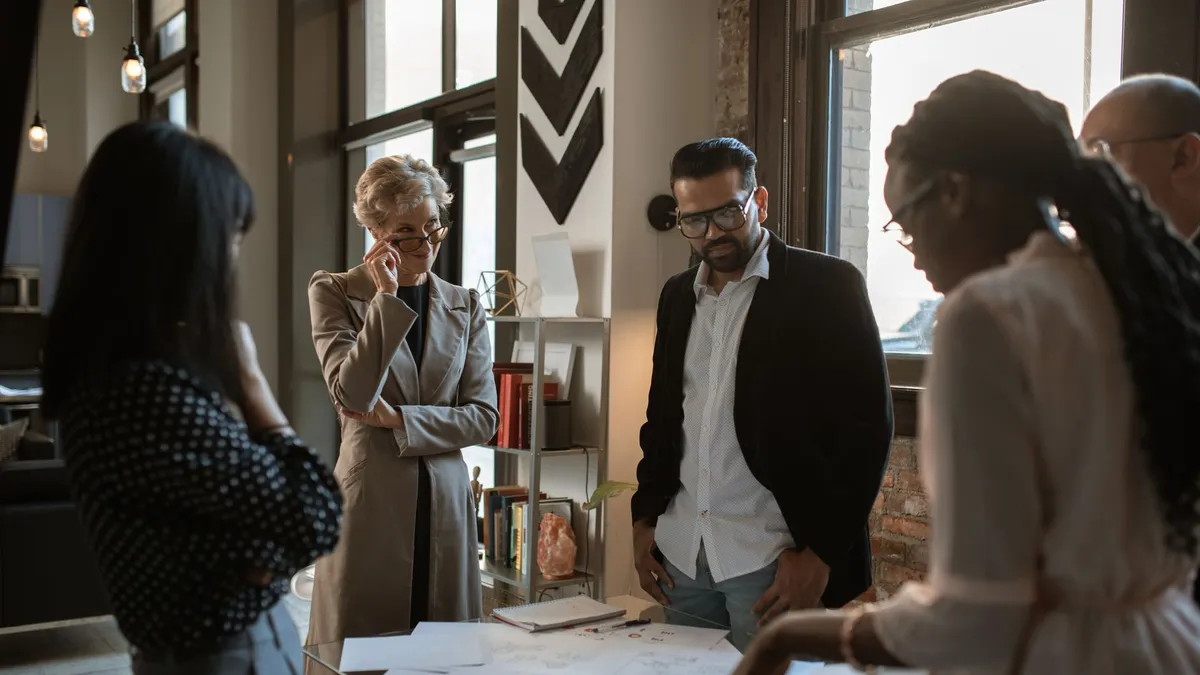 A diverse group of professionals discussing project plans in a modern office setting.