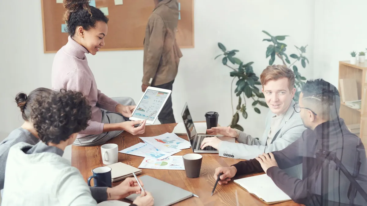 A diverse group of professionals discussing ideas in a modern office setting. Perfect for business and teamwork concepts.