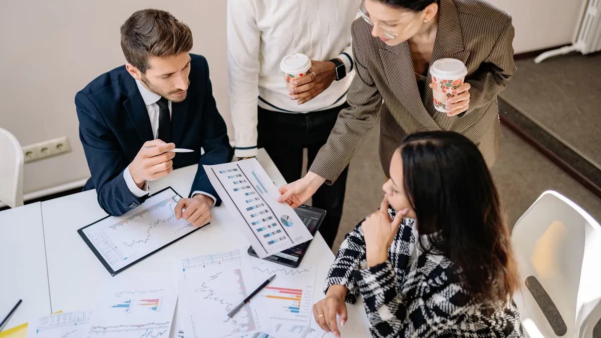 Four colleagues discuss data and strategy in an office setting.