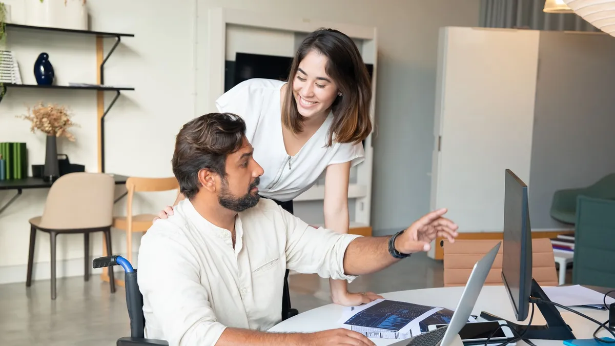 Interracial colleagues working together on a project in a modern office setting, showcasing teamwork and inclusivity.