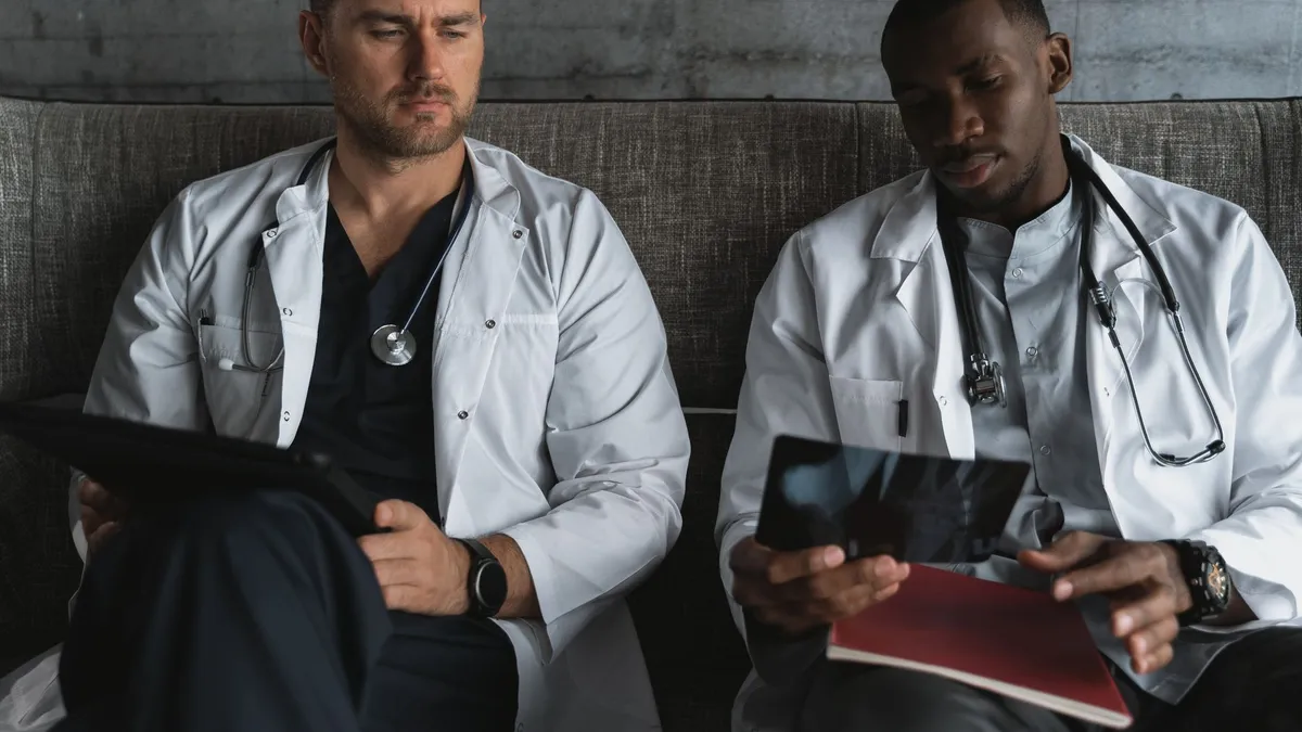 Two doctors analyze X-ray films in a medical office for diagnosis.