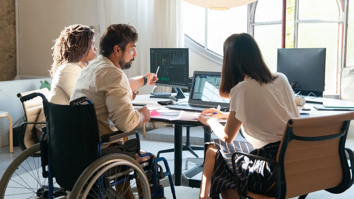 Diverse group of coworkers in a bright office working together around a table.