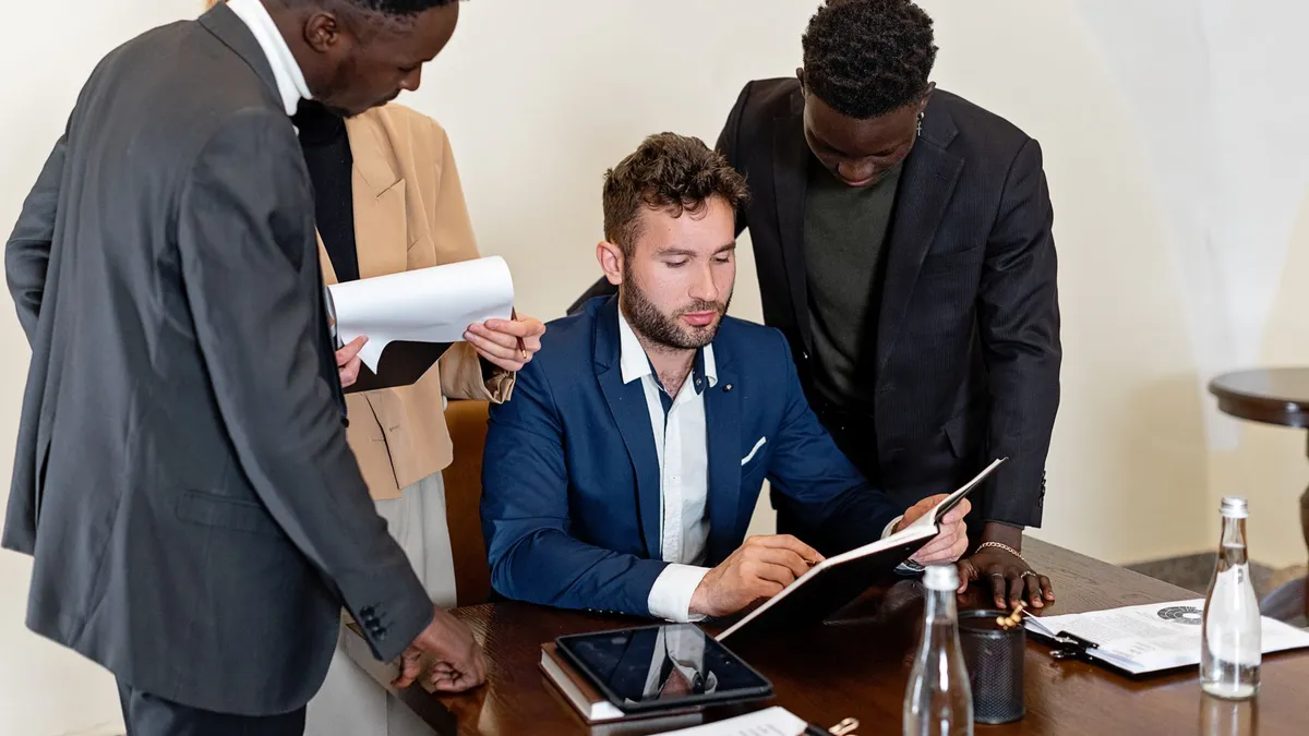 A diverse team collaborating in an office meeting, focusing on documents and teamwork.