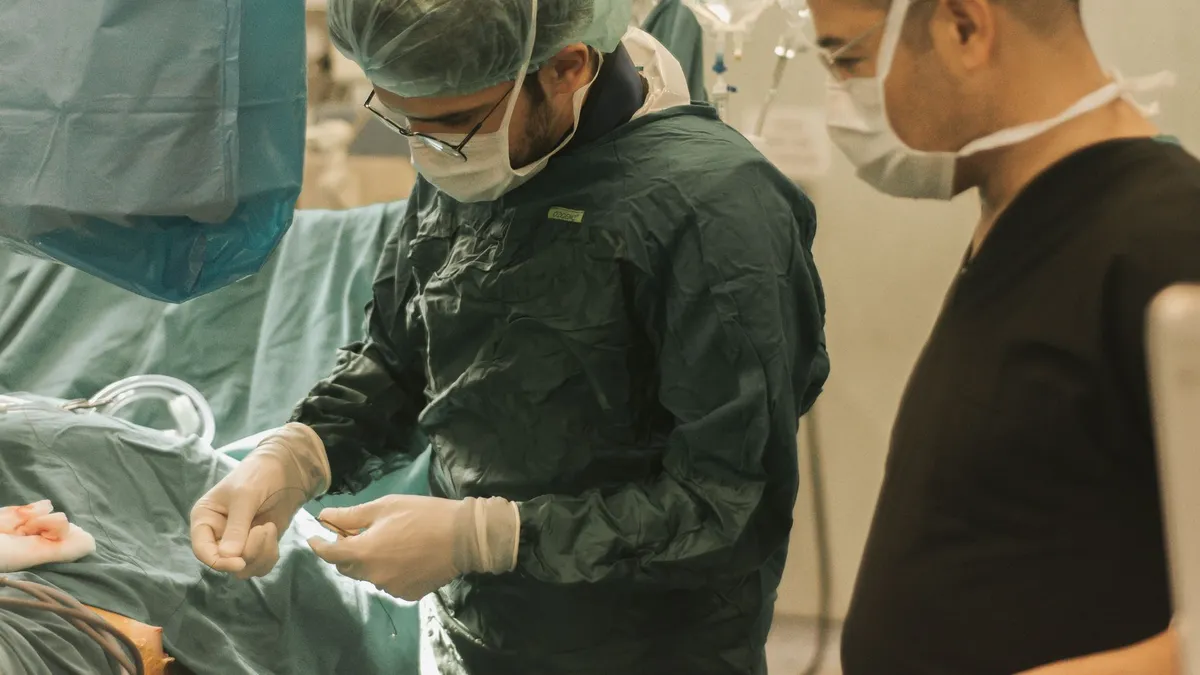 Two surgeons focused on a medical procedure in an operating room, highlighting teamwork in healthcare.